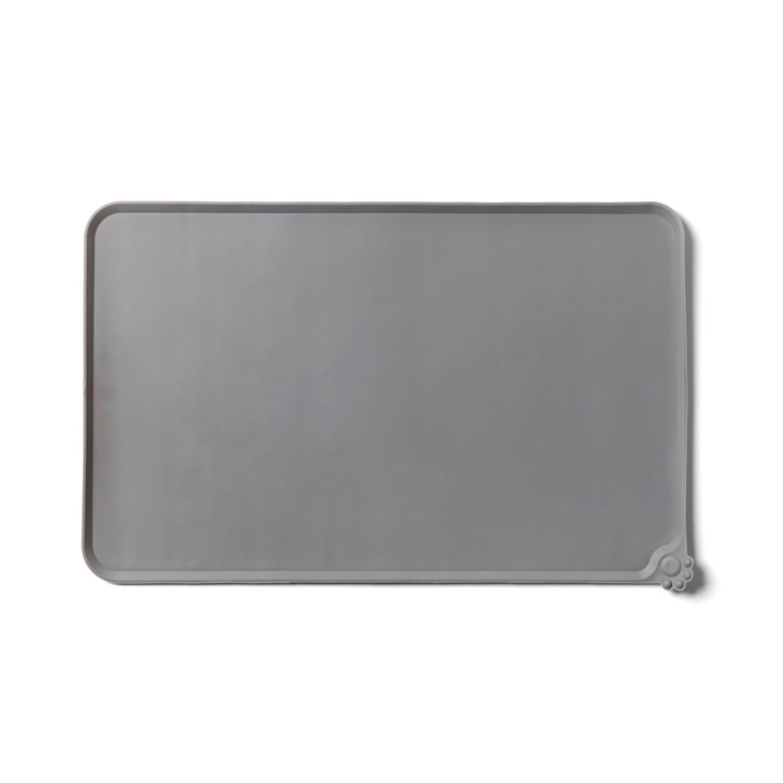 A rectangular gray silicone tray with slightly raised edges and a small paw design in one corner.